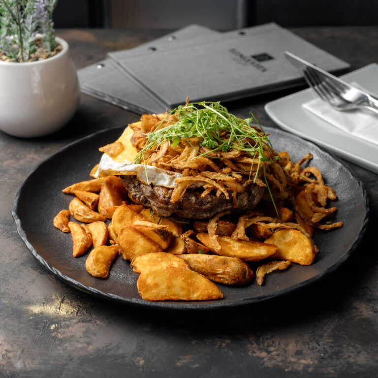 Marha rostályos Rib eye-ból steak burgonyával, lyoni hagyma, tükörtojás, borsmártás